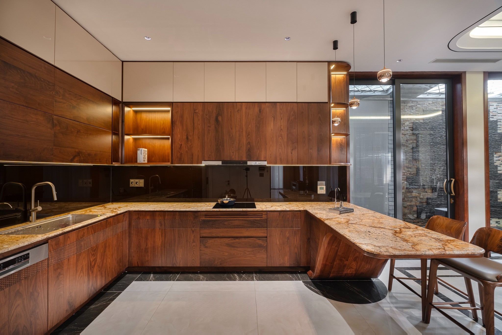 Mẫu tủ bếp chữ L với bàn đảo liền kề, gỗ óc chó và mặt đá granite vân vàng